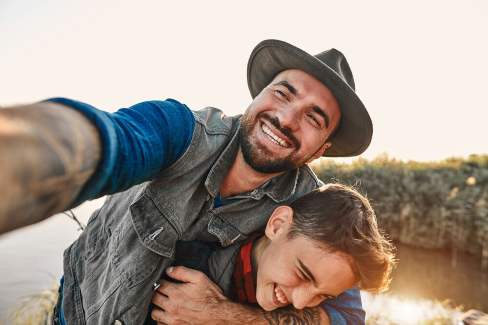 Man embracing sun while laughing during a fishing trip.