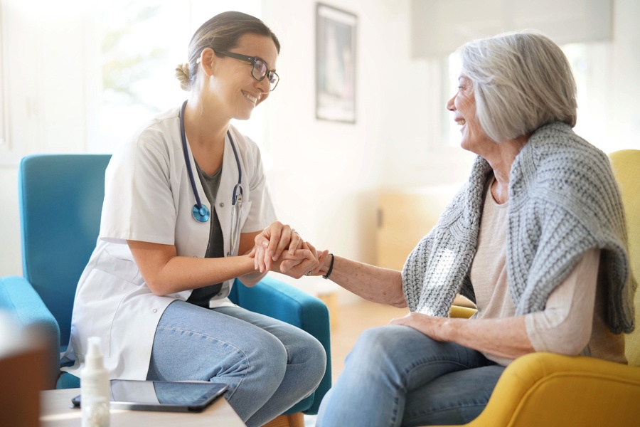 Doctor in short scrubs reassures older woman about drug detox.